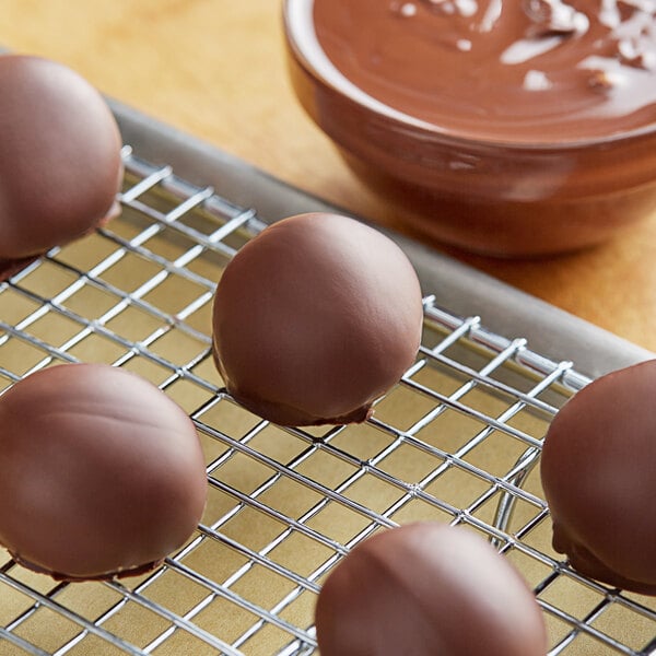Semi-sweet chocolate balls on a metal cooling rack.