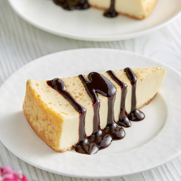 A slice of cheesecake with DaVinci Gourmet chocolate sauce on a plate.