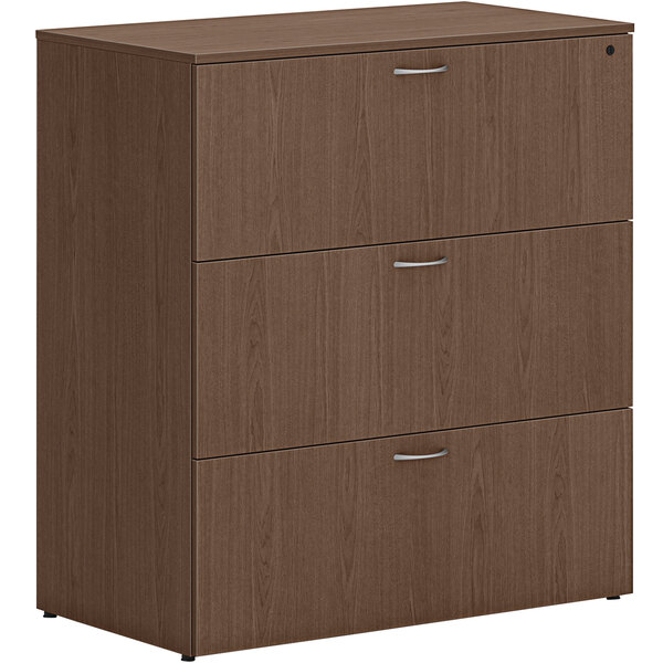 A brown HON lateral file cabinet with 3 drawers and silver handles.
