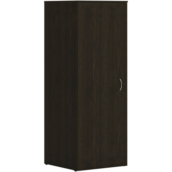 A HON Java Oak laminate wardrobe with a door and silver handles.