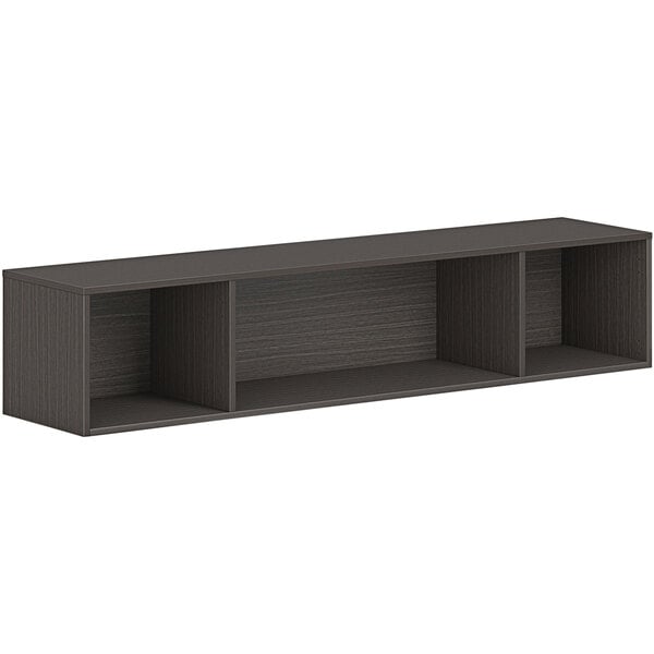 A black HON wall mounted open storage cabinet with three shelves.
