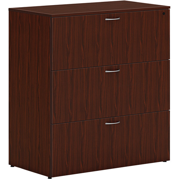 A brown wooden HON lateral file cabinet with 3 drawers and silver handles.