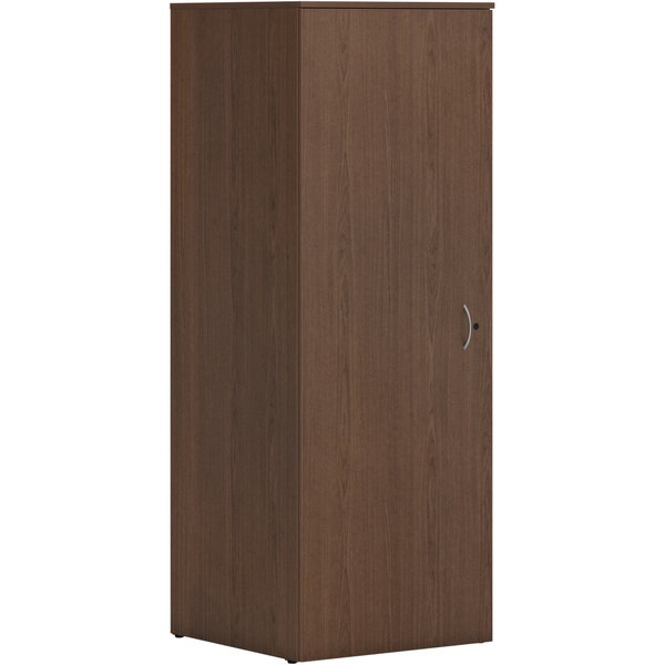 A HON sepia walnut laminate wardrobe cabinet with a silver handle.