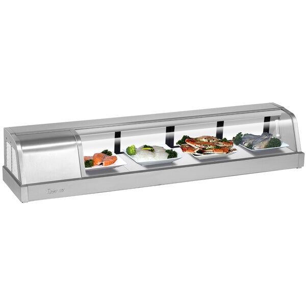 A Turbo Air stainless steel curved glass refrigerated sushi case filled with a variety of food.