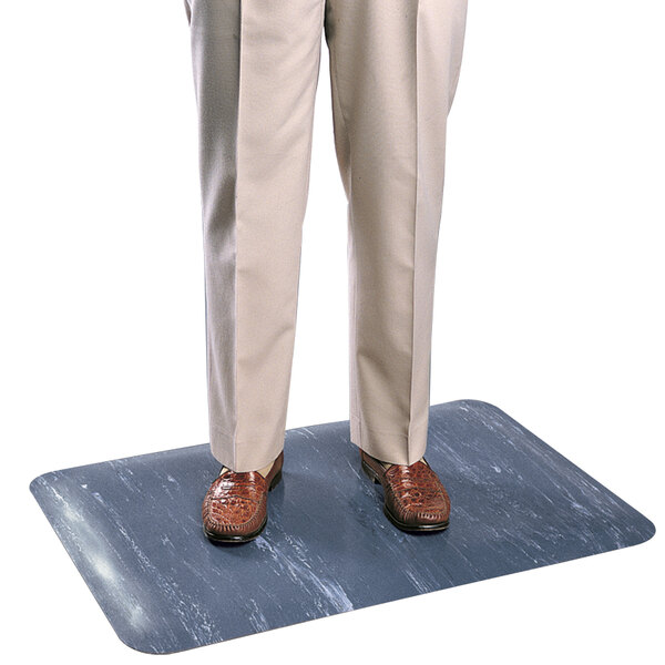 A man standing on a marbled blue Cactus Mat rubber anti-fatigue mat.