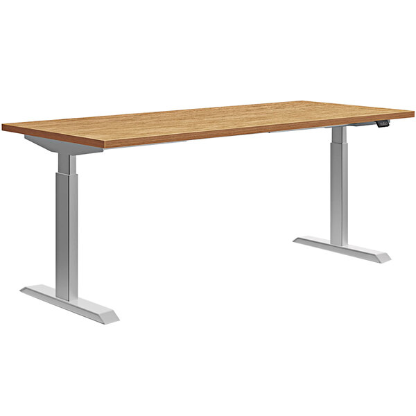 A HON Coze Coordinate height-adjustable desk with a natural recon wood top and silver metal legs.