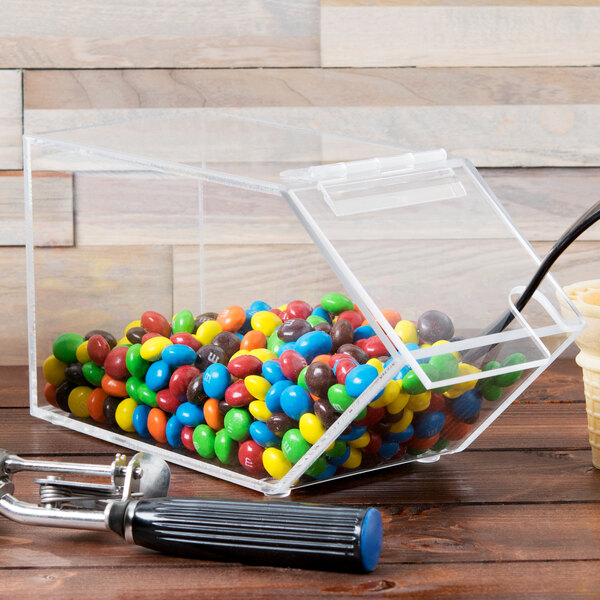 A clear plastic Cal-Mil topping dispenser with a notch lid containing candy.