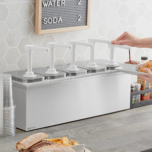 A stainless steel ServSense condiment dispenser on a counter with 5 plastic pumps.