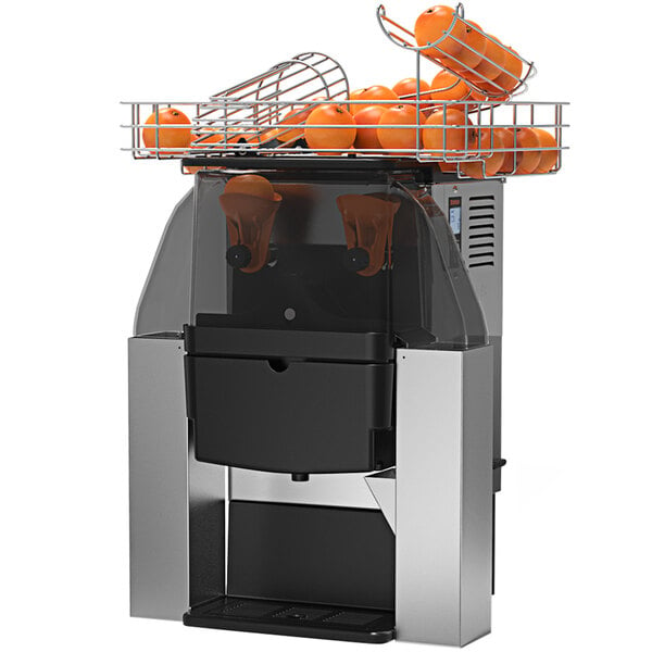 A Zummo commercial juicer with oranges in chutes.