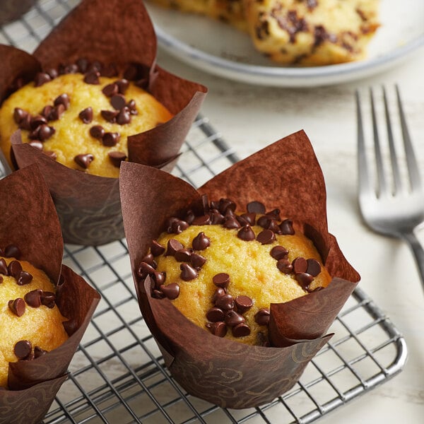 A group of semi-sweet chocolate chip muffins on a cooling rack.