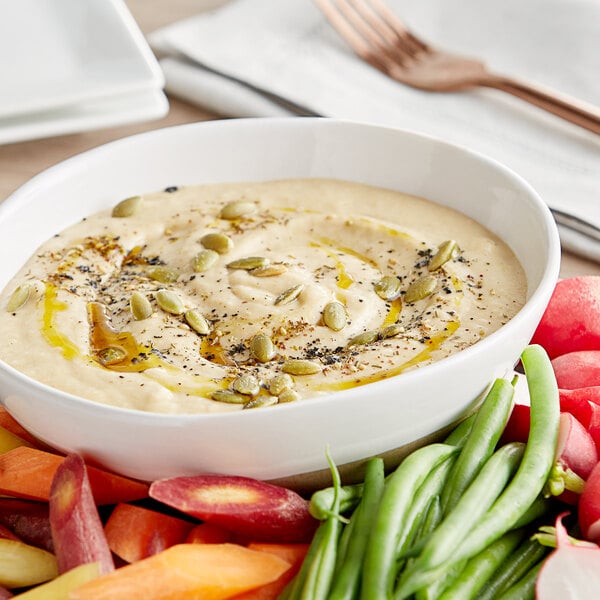 A bowl of baba ghanouj with vegetables.