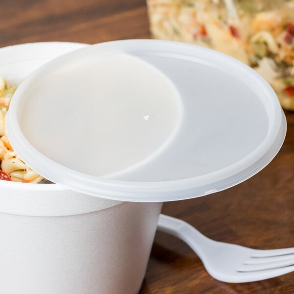 A Dart translucent plastic lid on a white container of food.