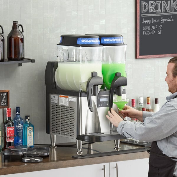 A man pouring green drink into a Bunn slushy machine.