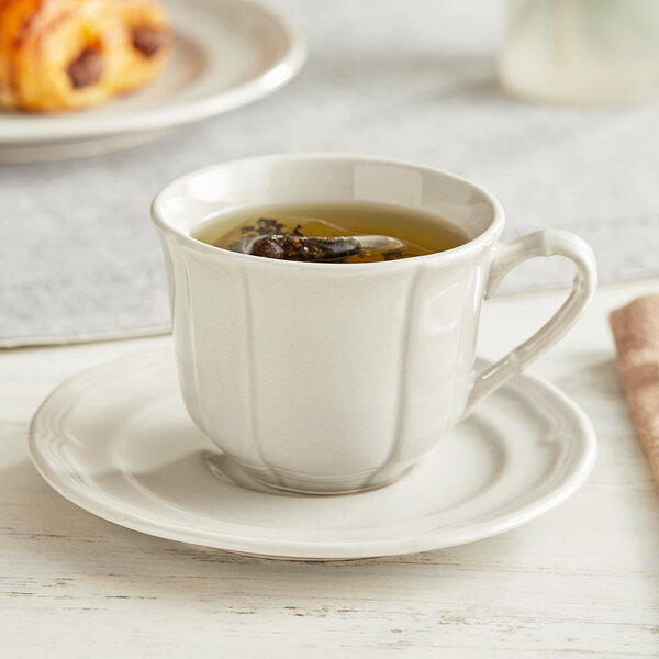 A warm gray Acopa Condesa porcelain cup of tea with a saucer.