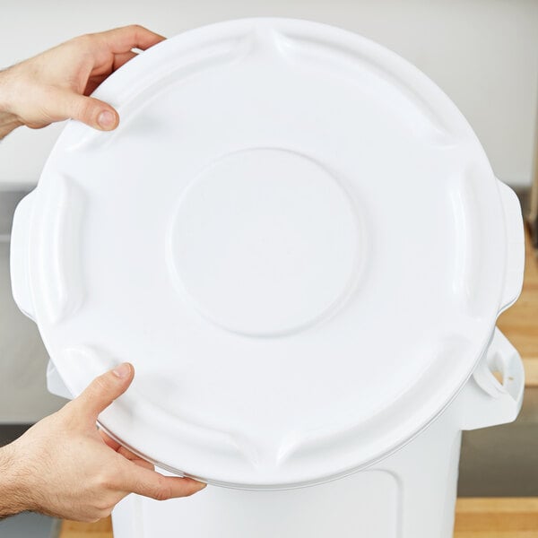 A person holding a white plastic lid.