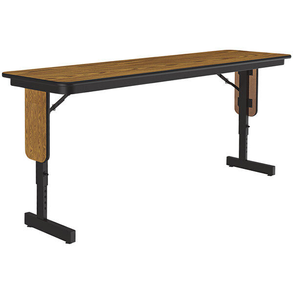 A Correll seminar table with a medium oak thermal-fused laminate top and black panel legs.