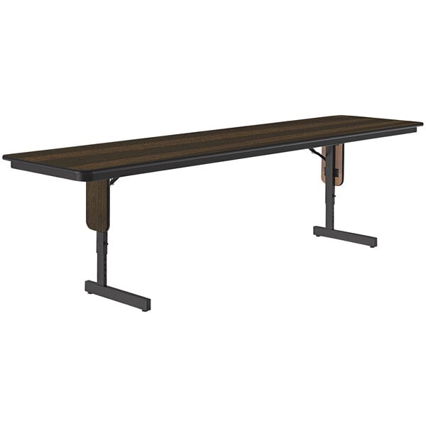 A long rectangular Correll seminar table with a walnut top and black panel legs.