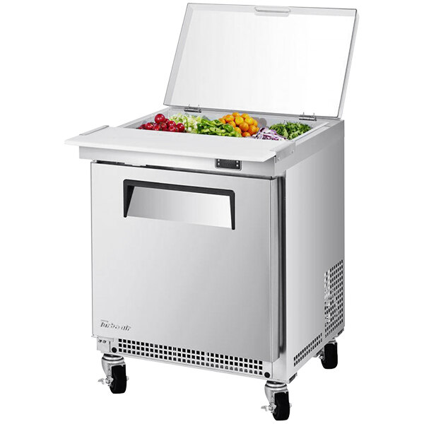 A Turbo Air stainless steel refrigerated salad prep table with clear lid on top.