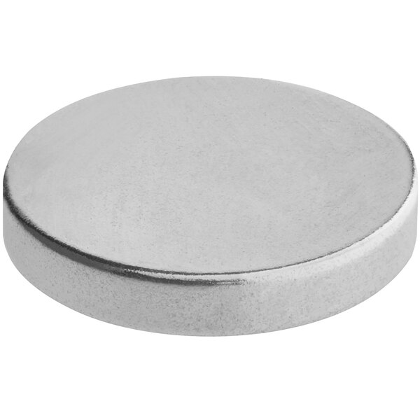 A silver round metal Amana grill magnet.