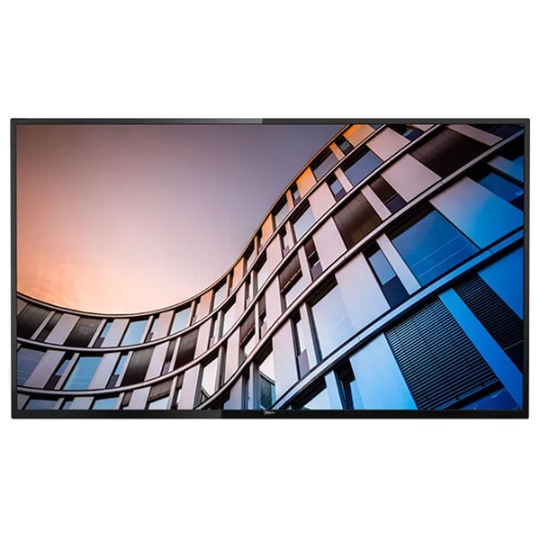 A Philips B-Line 65" Class 4K UHD Smart Professional LED Television screen on a curved building with windows.