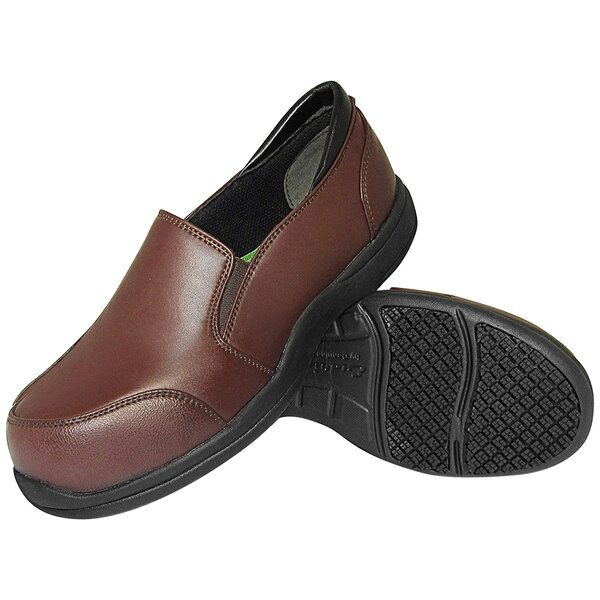 A pair of Genuine Grip chocolate brown leather composite toe shoes with a black sole.