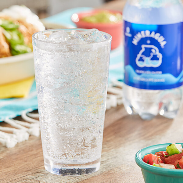 A close-up of a glass of Jarritos Mineragua sparkling water with ice.