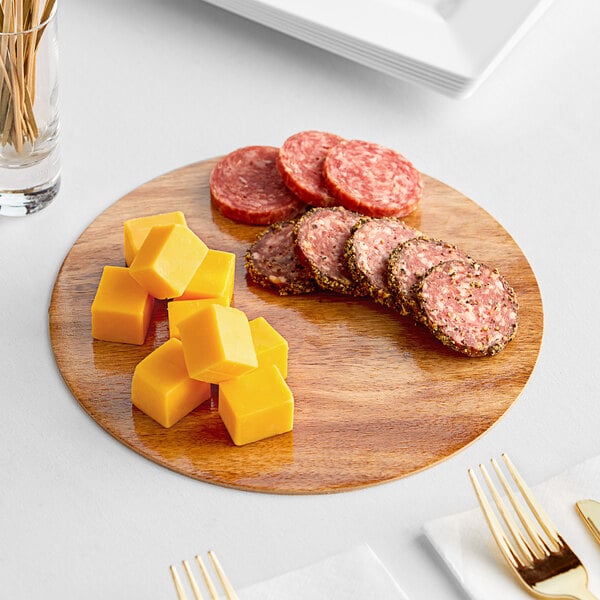 An Enjay reversible charcuterie board with cheese and sausage on it.
