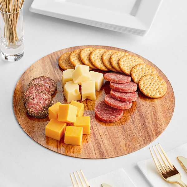 A wood and marble Enjay charcuterie board with cheese, crackers, and meat.