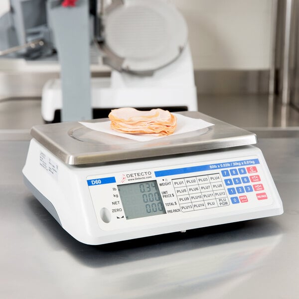A Cardinal Detecto D60 legal for trade scale weighing a plate of meat.