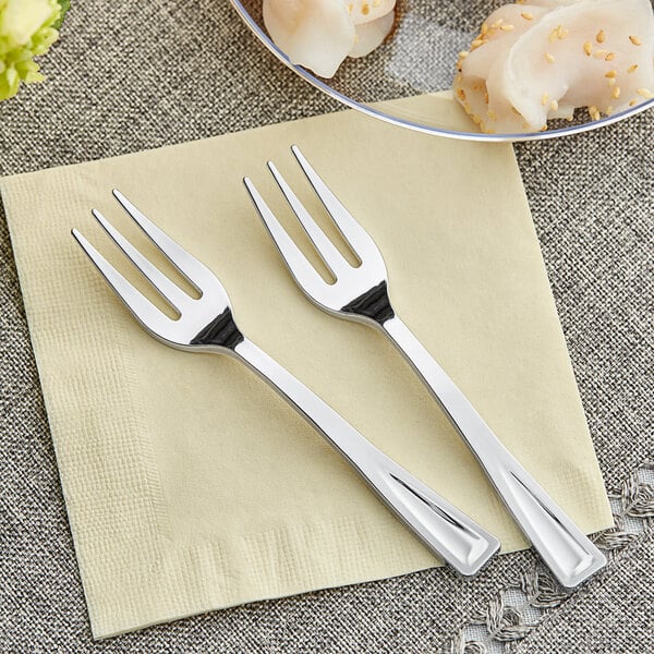 Two Visions silver plastic tasting forks on a napkin.