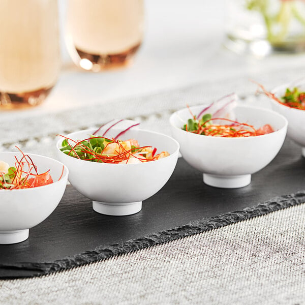 A table with a tray of small white bowls with food in them.