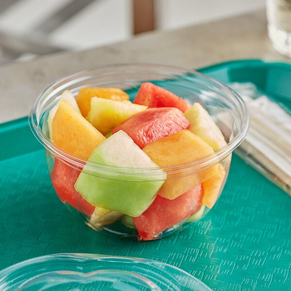 A World Centric compostable clear PLA deli bowl filled with sliced fruit.