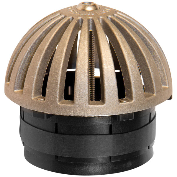 A close up of a black and gold metal Guardian Drain Lock dome with a hole in it.