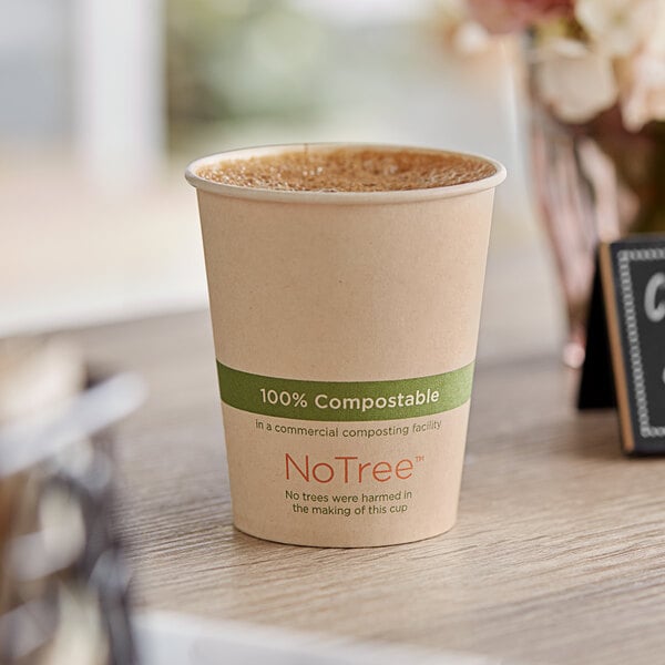 A World Centric Natural compostable paper hot cup filled with coffee on a table.