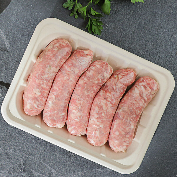 A World Centric compostable fiber meat tray of raw sausages.