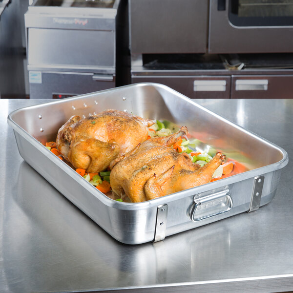 A Vollrath aluminum roaster pan with two roasting chickens.
