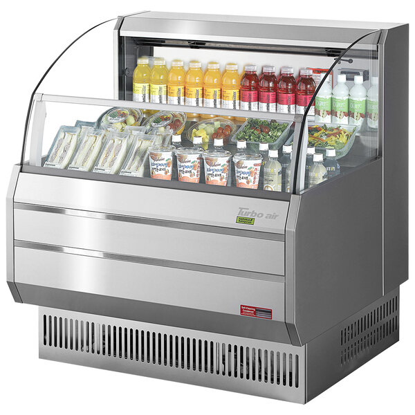 A Turbo Air stainless steel horizontal refrigerated display case on a counter with drinks inside.