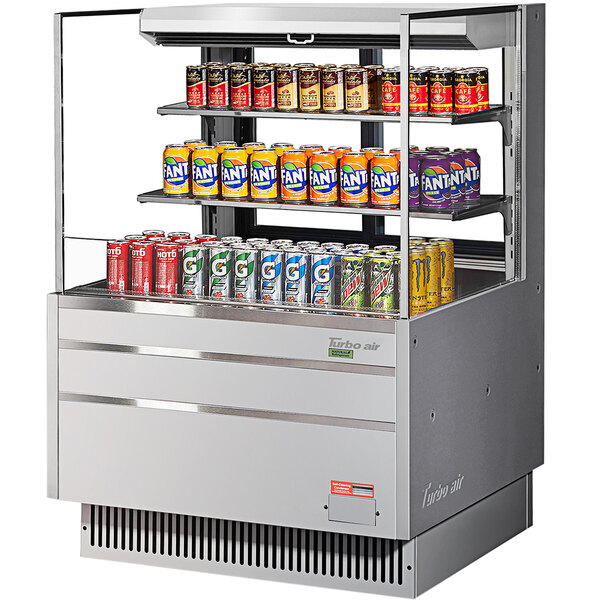 A Turbo Air horizontal refrigerated open curtain merchandiser with cans of soda on shelves.