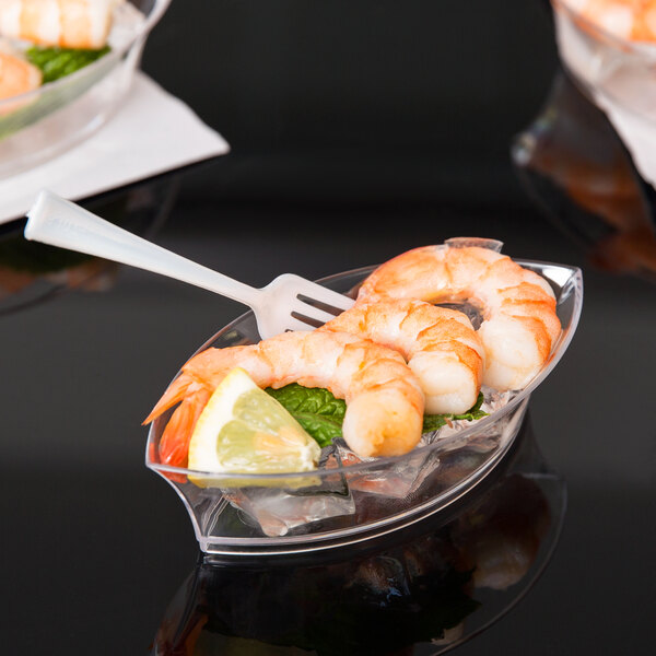 A Fineline clear plastic tray with shrimp, a lemon wedge, and a fork.