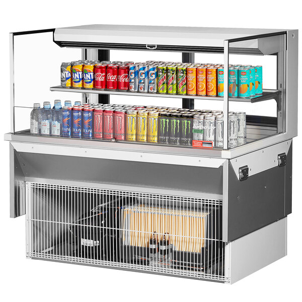 A Turbo Air drop-in refrigerated display case with cans of soda and different flavors on shelves.