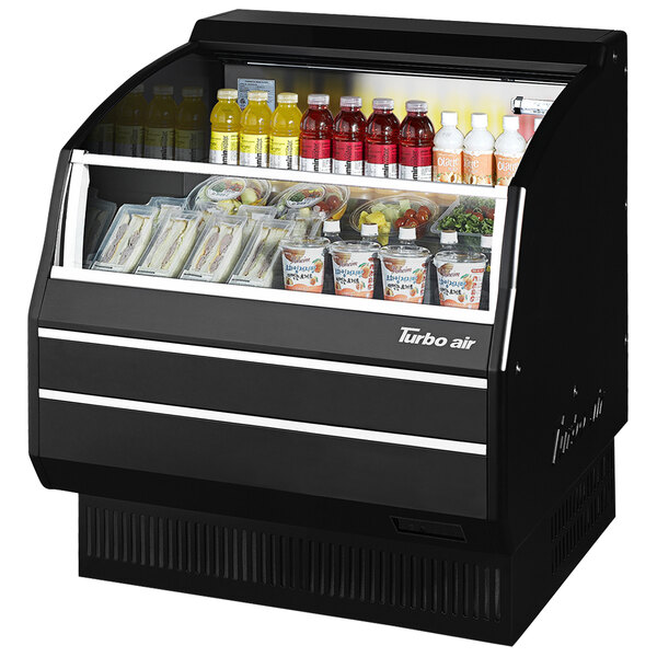 A black Turbo Air refrigerated display case with food and drinks inside.