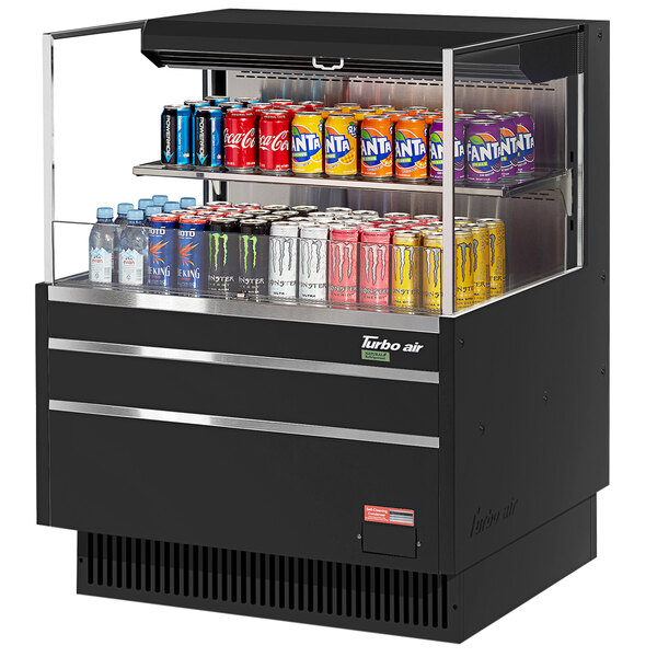 A black Turbo Air horizontal refrigerated open curtain merchandiser filled with a variety of canned drinks.