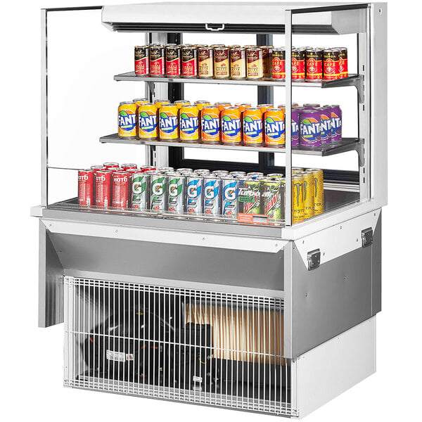 A white Turbo Air drop-in refrigerated display case with cans on shelves.
