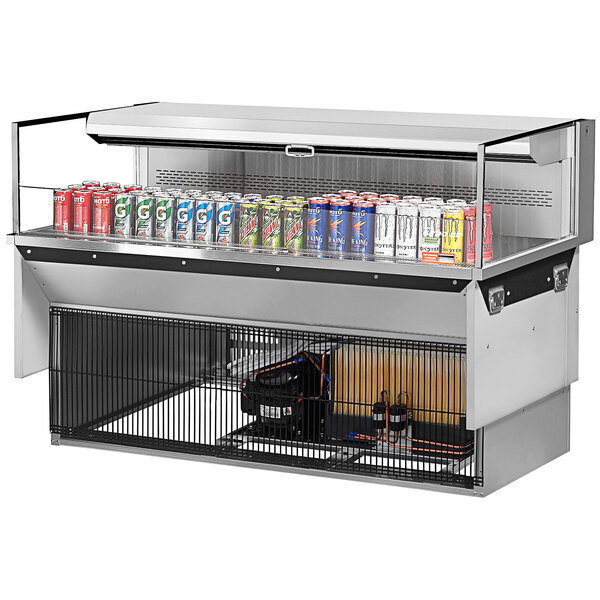 A Turbo Air stainless steel drop-in refrigerated display case on a counter with cans of soda in it.