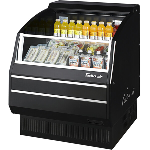 A black refrigerated open curtain merchandiser with drinks and snacks inside.