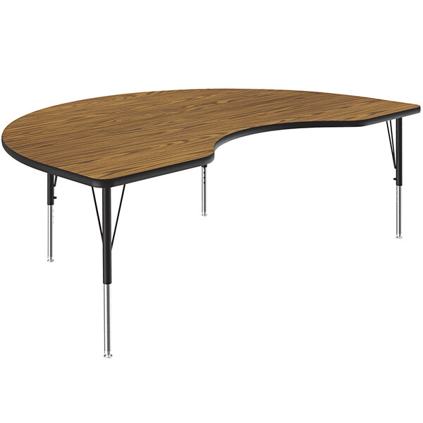 A wooden Correll kidney-shaped activity table with metal legs.