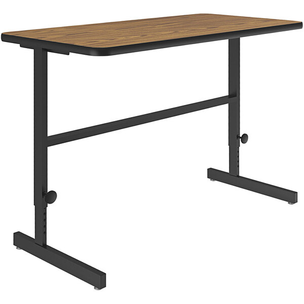 A medium oak Correll standing height work station with a black frame.