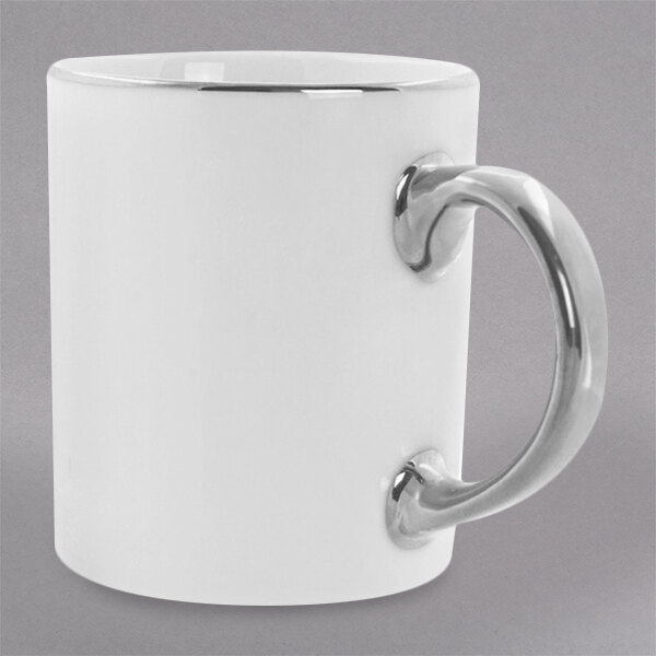 A white 10 Strawberry Street porcelain mug with a silver handle.