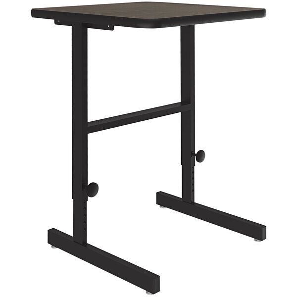 A Correll walnut standing height work station with a black top and metal base.