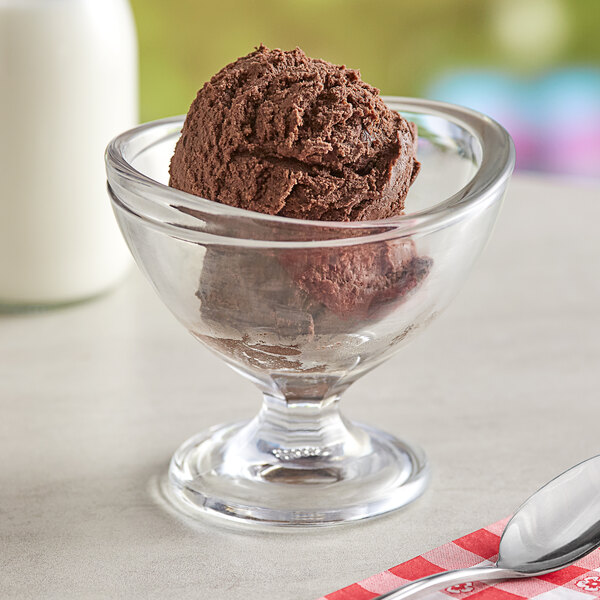 A glass bowl of brown Oringer Double Dutch chocolate ice cream with a spoon.